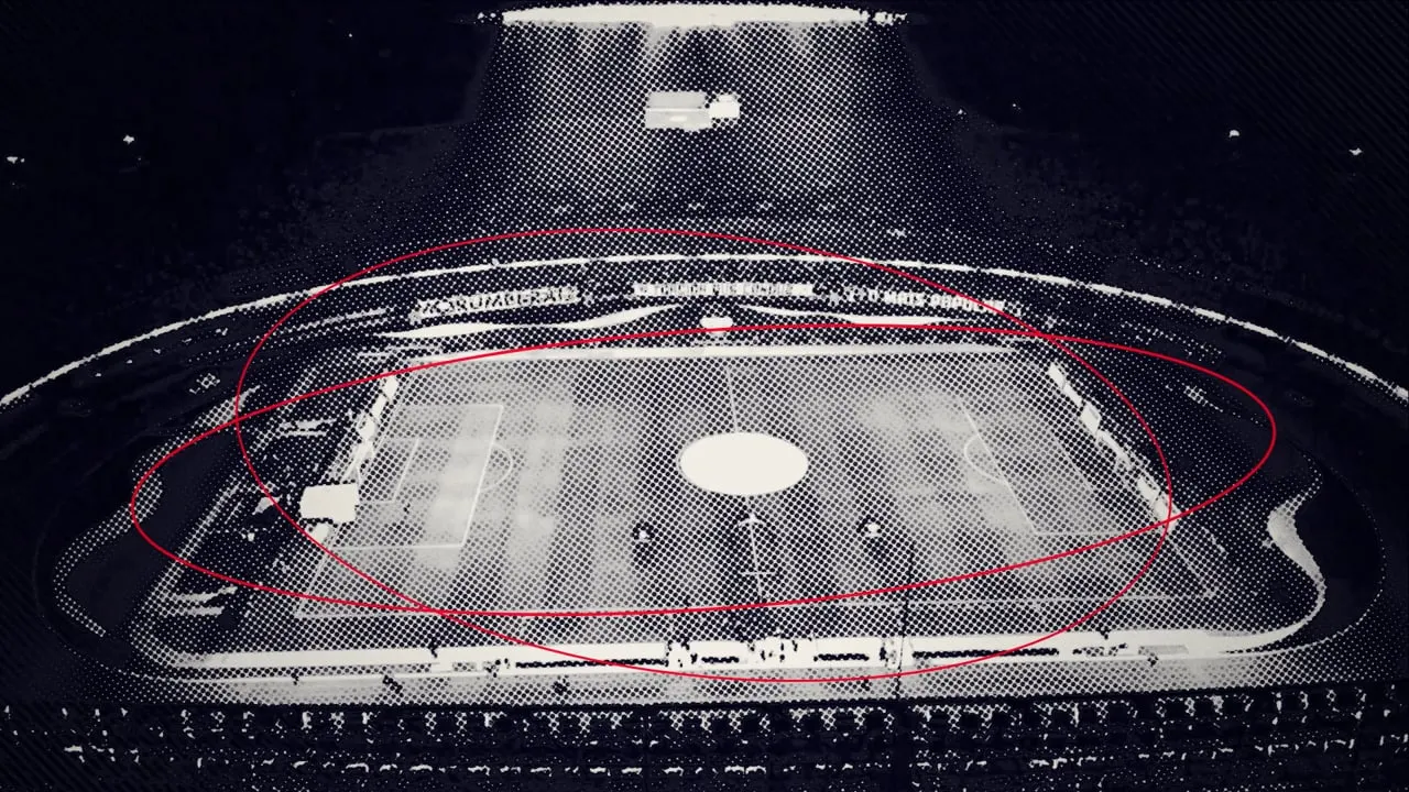 A football stadium from above at night, printed as a halftone, red lines drawn around the pitch.
